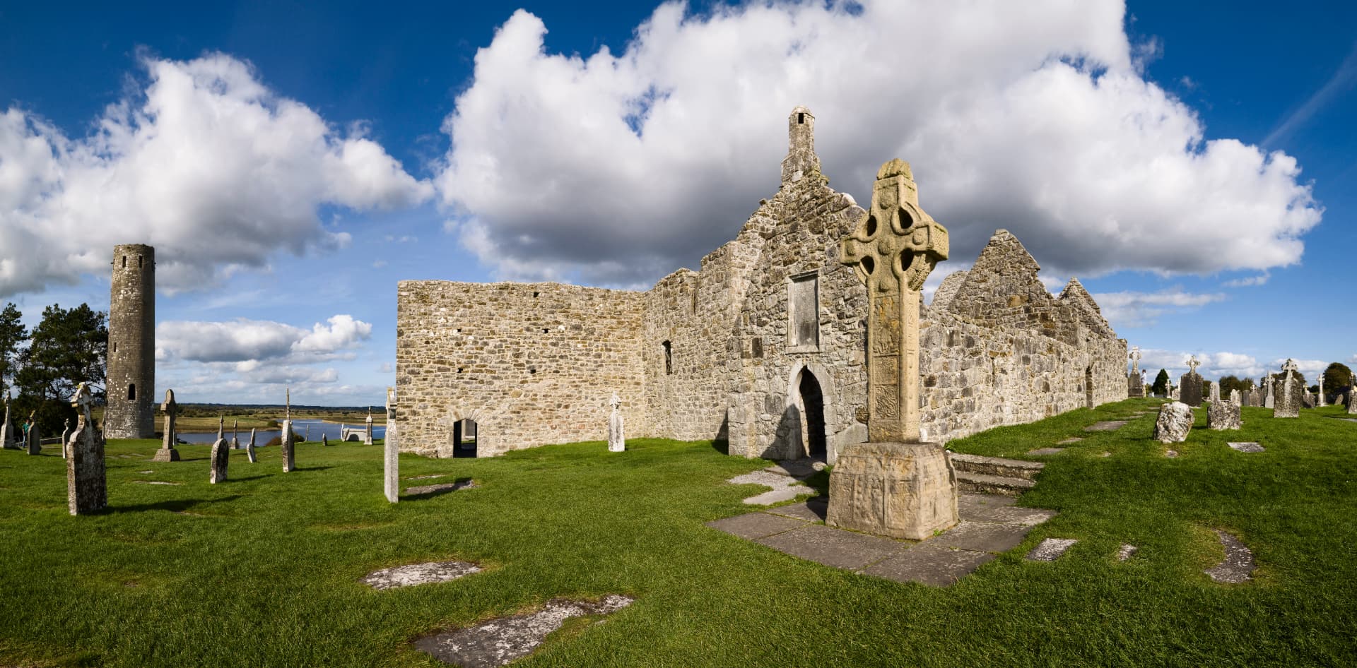 The ruins of Clonmacnoise monastic site in County Offaly, with the cathedral, round tower and Cross of the Scriptures standing above the River Shannon