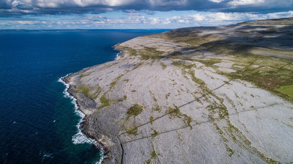 Aerial view of the Burren's glacially-smoothed limestone pavement meeting the Atlantic on the north Clare coast