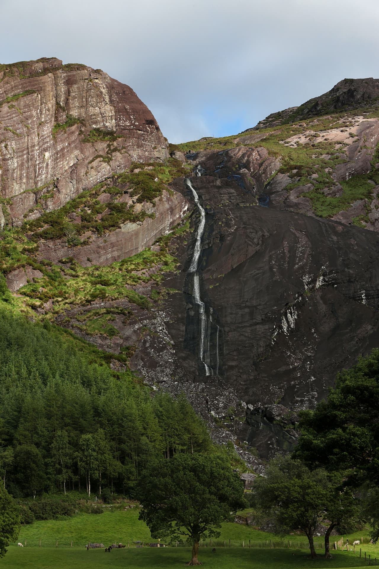 Gleninchaquin Park waterfall cascading down a rocky Kerry valley above green woodland