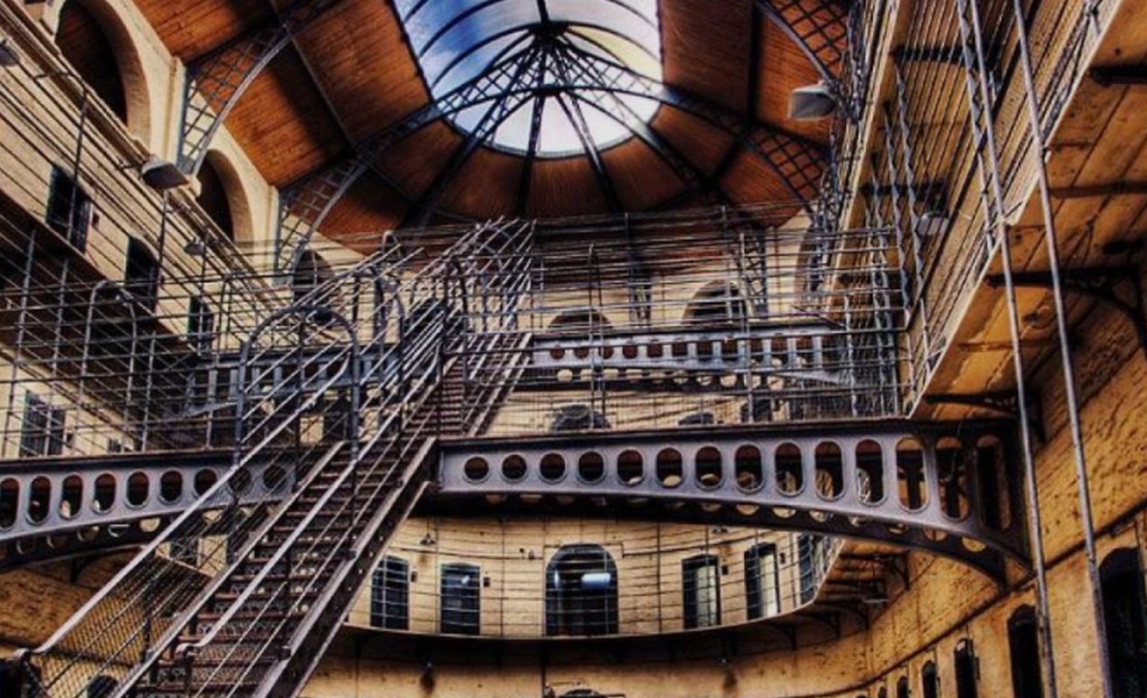 The East Wing of Kilmainham Gaol, Dublin — tiered cell galleries, iron staircases and the vaulted skylit roof